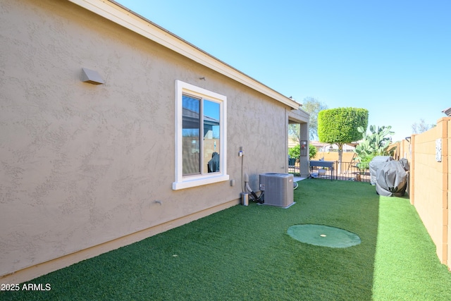 view of yard featuring fence and central AC