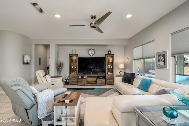 living area featuring tile patterned flooring, recessed lighting, visible vents, and a ceiling fan