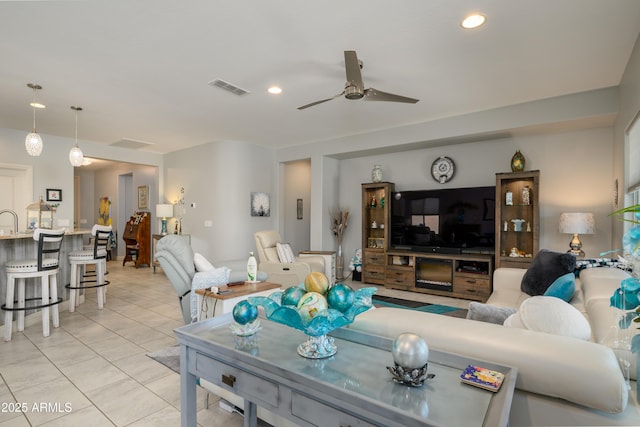 living area with light tile patterned floors, visible vents, recessed lighting, and ceiling fan