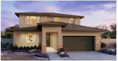 prairie-style house featuring a garage, concrete driveway, and stucco siding