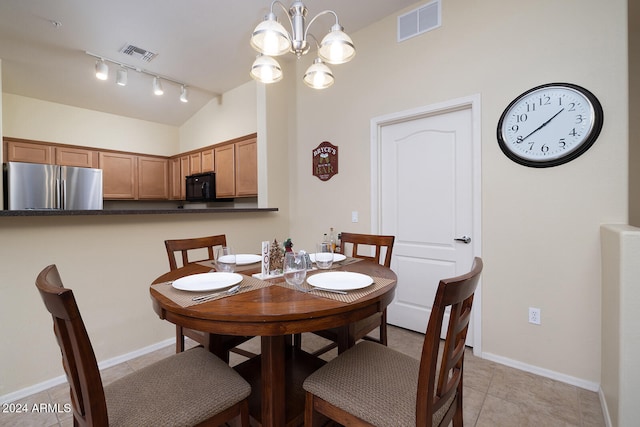 tiled dining room featuring lofted ceiling and an inviting chandelier