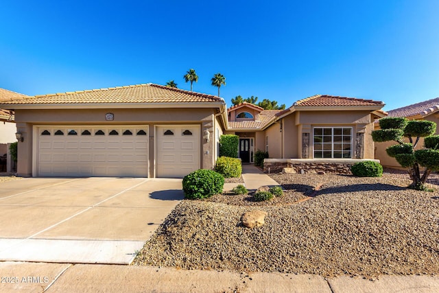 view of front facade featuring concrete driveway, a garage, stucco siding, and a tile roof