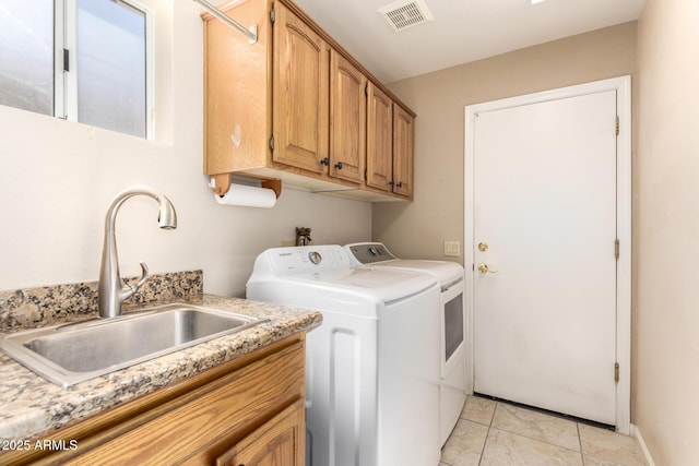 laundry room featuring independent washer and dryer, cabinet space, and light tile patterned floors