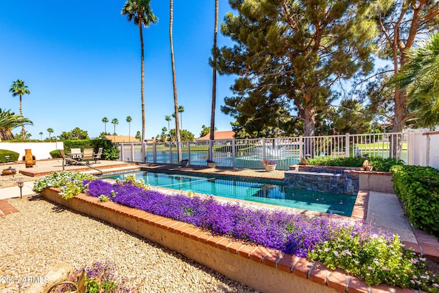 view of swimming pool featuring fence, a pool with connected hot tub, and a patio