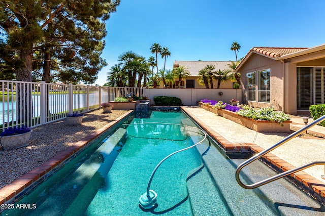 view of swimming pool featuring a fenced backyard and a water view