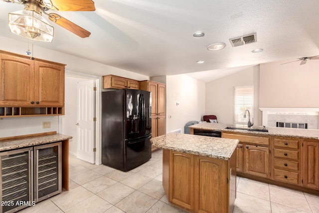 kitchen with black appliances, a sink, wine cooler, ceiling fan, and a kitchen island