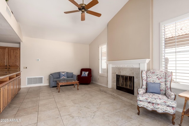 living area featuring a ceiling fan, high vaulted ceiling, a fireplace, and baseboards