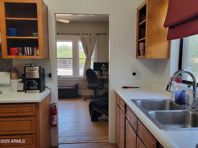 405 Powell St, Bisbee, AZ 85603 - kitchen with a sink, light countertops, brown cabinets, wood finished floors, and a desk