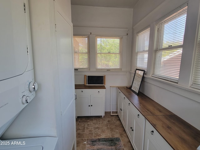 405 Powell St, Bisbee, AZ 85603 - laundry room featuring stacked washer / drying machine, cabinet space, and stone finish floors
