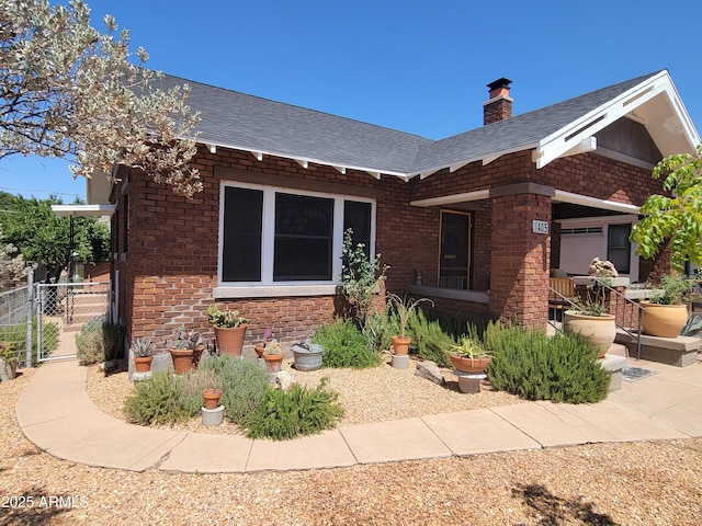 405 Powell St, Bisbee, AZ 85603 - view of front of property with brick siding, roof with shingles, a chimney, and fence