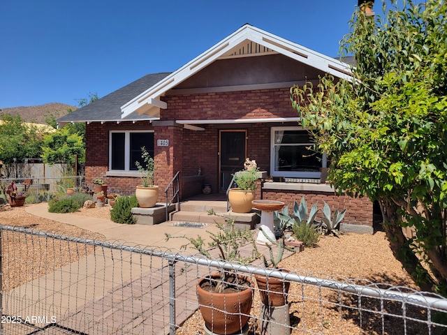 405 Powell St, Bisbee, AZ 85603 - craftsman-style house with brick siding, fence, a mountain view, and a shingled roof