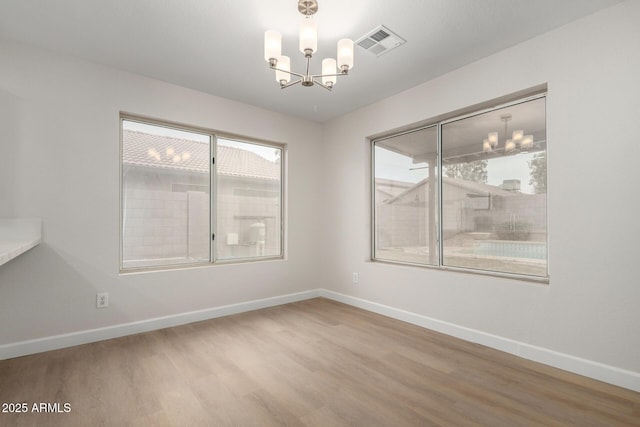 unfurnished dining area with a chandelier, visible vents, and plenty of natural light