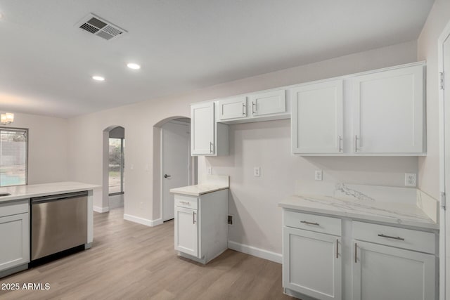 kitchen featuring visible vents, baseboards, light wood-style flooring, arched walkways, and stainless steel dishwasher