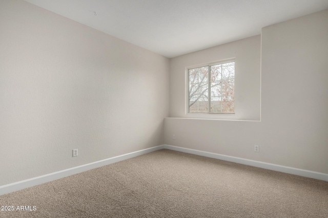 empty room with baseboards and carpet