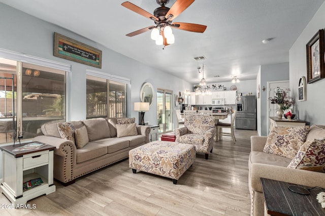 living room with ceiling fan and light hardwood / wood-style flooring