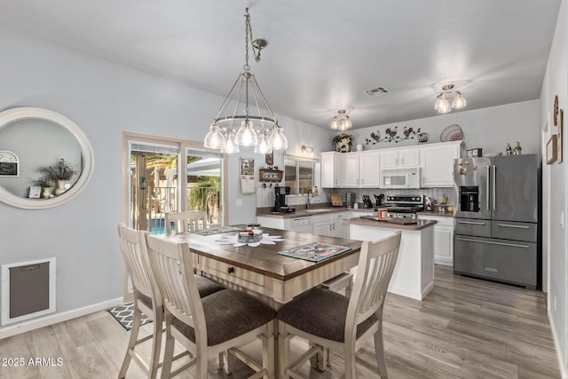 dining space featuring light wood-type flooring and sink