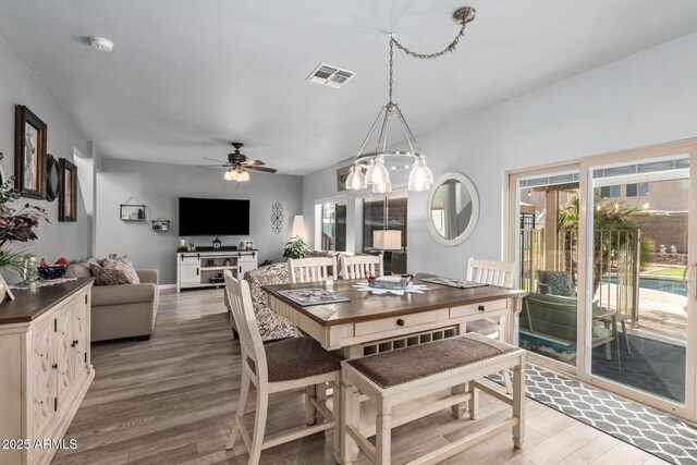 dining area with ceiling fan and wood-type flooring