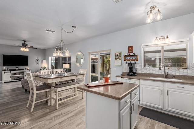 kitchen featuring ceiling fan, sink, pendant lighting, light hardwood / wood-style flooring, and white cabinetry