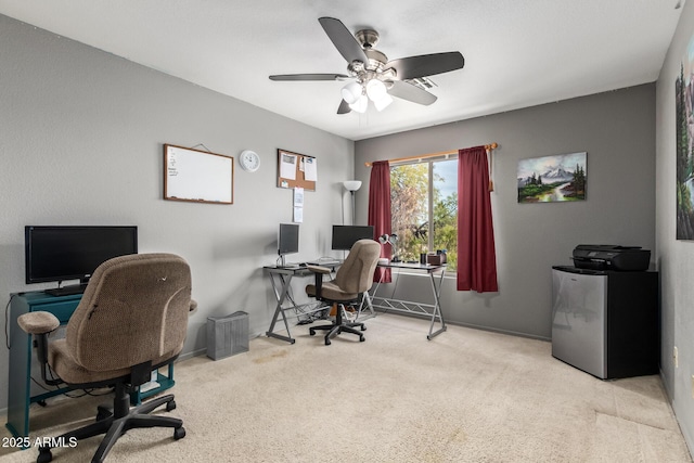 carpeted office space with ceiling fan