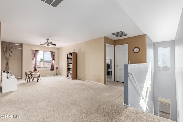 interior space featuring light colored carpet and ceiling fan