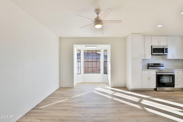 kitchen with ceiling fan, white cabinets, stainless steel appliances, and light wood-type flooring