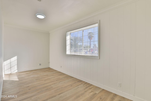 empty room featuring crown molding and light hardwood / wood-style flooring