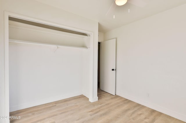 unfurnished bedroom with a closet, light hardwood / wood-style floors, and ceiling fan