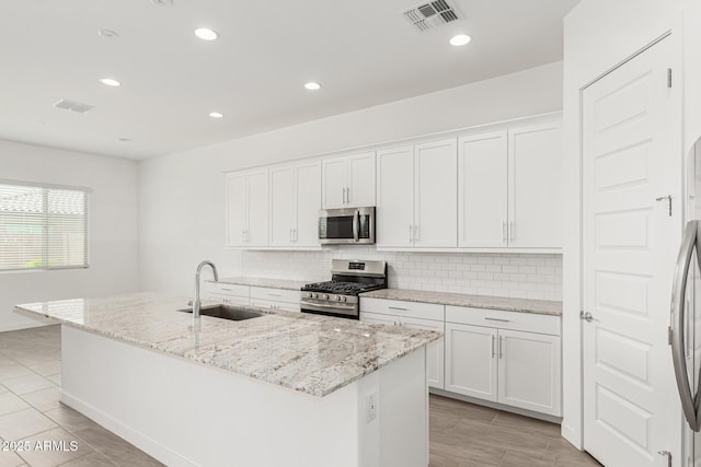 19151 W Coolidge St, Litchfield Park, AZ 85340 - kitchen featuring appliances with stainless steel finishes, a sink, backsplash, white cabinetry, and recessed lighting