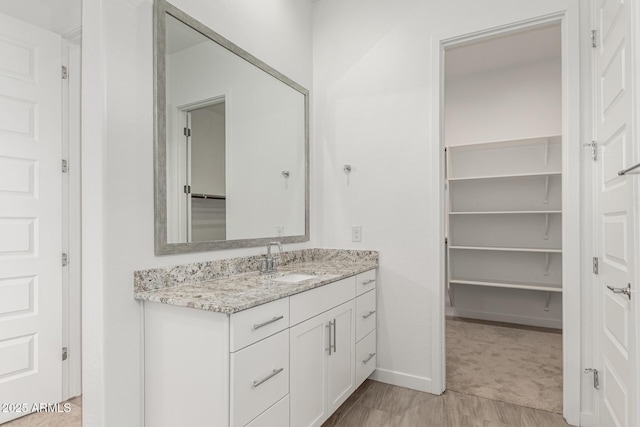 19151 W Coolidge St, Litchfield Park, AZ 85340 - bathroom with vanity, baseboards, and a spacious closet