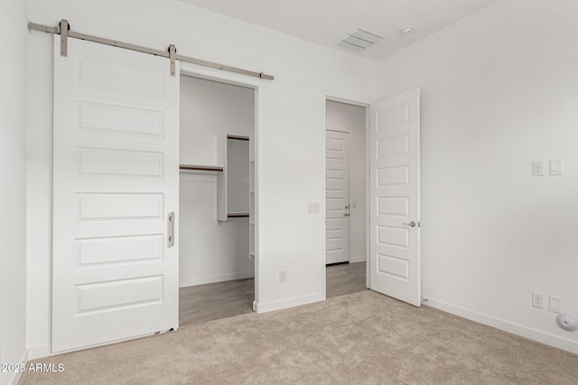 19151 W Coolidge St, Litchfield Park, AZ 85340 - unfurnished bedroom with carpet, baseboards, a closet, and a barn door