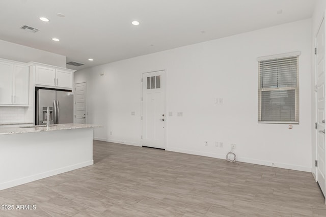 19151 W Coolidge St, Litchfield Park, AZ 85340 - kitchen with stainless steel fridge with ice dispenser, a sink, recessed lighting, white cabinets, and baseboards