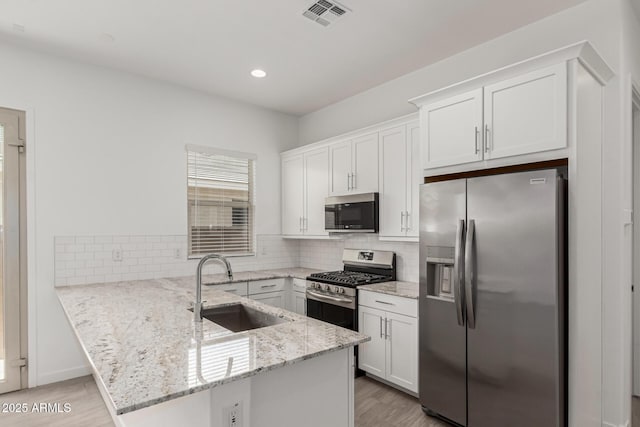 19151 W Coolidge St, Litchfield Park, AZ 85340 - kitchen featuring stainless steel appliances, a sink, a peninsula, white cabinetry, and recessed lighting
