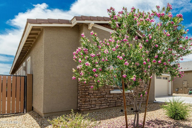 19151 W Coolidge St, Litchfield Park, AZ 85340 - view of property exterior with stucco siding, an attached garage, driveway, and a tile roof