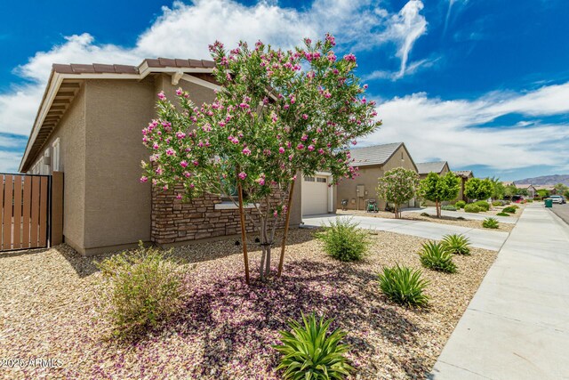 19151 W Coolidge St, Litchfield Park, AZ 85340 - view of front of property with stucco siding, concrete driveway, an attached garage, and stone siding