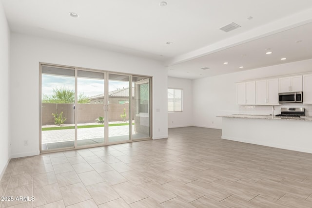 19151 W Coolidge St, Litchfield Park, AZ 85340 - unfurnished living room featuring recessed lighting, baseboards, and a sink