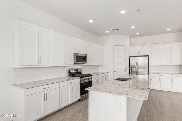 19151 W Coolidge St, Litchfield Park, AZ 85340 - kitchen with appliances with stainless steel finishes, a sink, backsplash, white cabinets, and recessed lighting