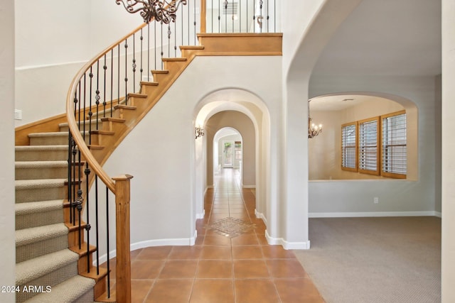 tiled entryway featuring a notable chandelier