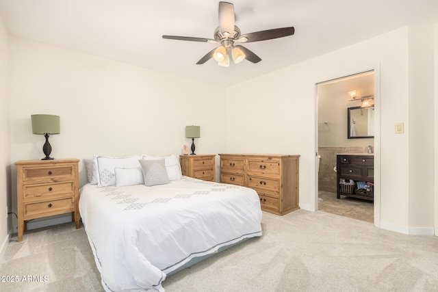 bedroom featuring light colored carpet, ceiling fan, and connected bathroom