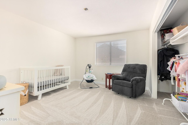 bedroom with light colored carpet and a nursery area