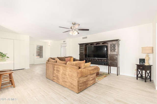 living room with light hardwood / wood-style floors and ceiling fan