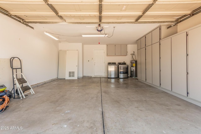 garage featuring water heater, independent washer and dryer, and a garage door opener