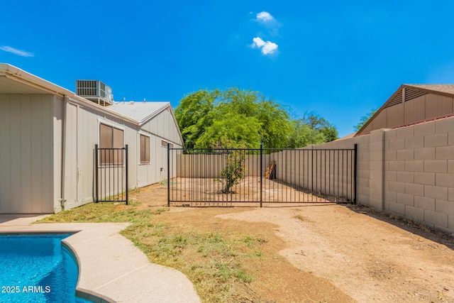 view of yard with central AC and a fenced in pool