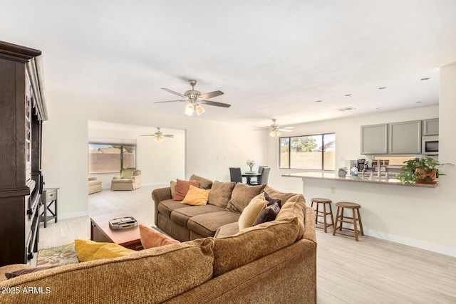 living room with light wood-type flooring and ceiling fan