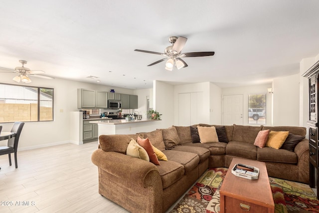 living room featuring ceiling fan and light hardwood / wood-style floors