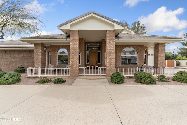 1321 W Gardenia Ave, Phoenix, AZ 85021 - single story home with a tiled roof, a gate, brick siding, and covered porch