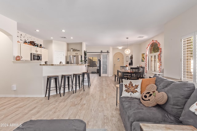 living room featuring light wood-type flooring and a barn door