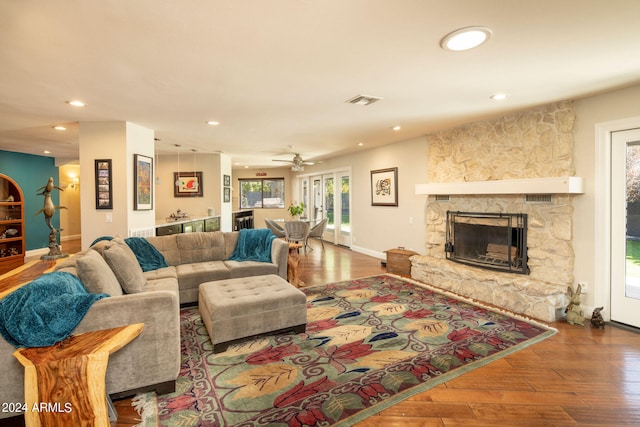 living room with a fireplace, ceiling fan, and hardwood / wood-style flooring