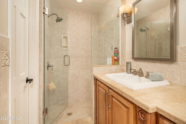 bathroom featuring decorative backsplash, tile walls, walk in shower, and vanity