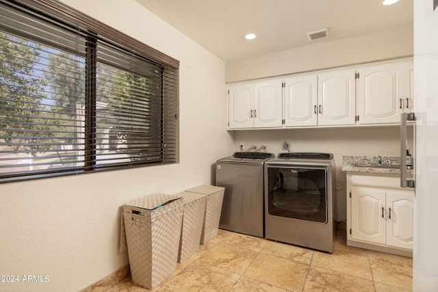 laundry area featuring sink, washer and dryer, and cabinets