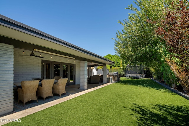 view of yard with a trampoline, outdoor lounge area, and a patio